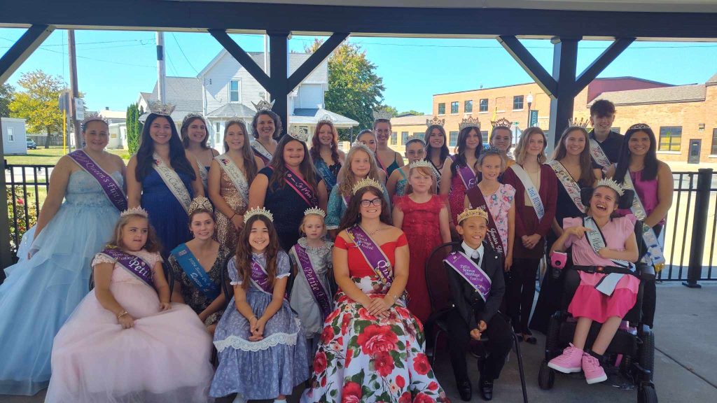 A large group of children and adults wearing crowns and sashes that represent their 2024 titles.